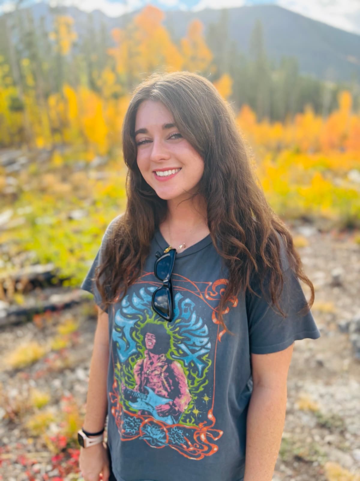Kelsie outdoors among golden autumn trees